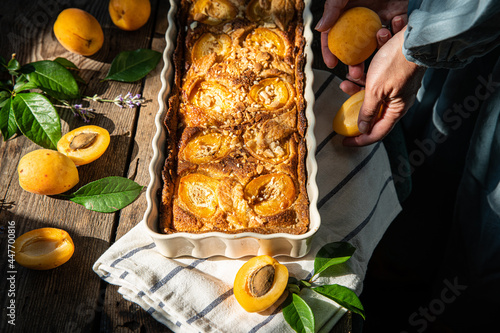 Apricot and frangipane tart in rectangular ceramic baking form on old wooden table. photo