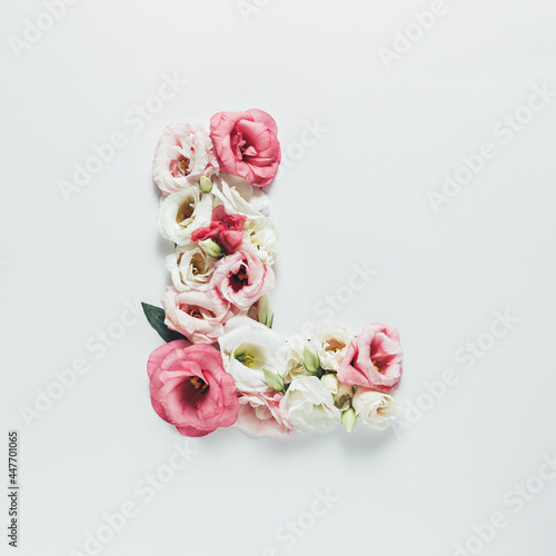 Letter L made with flower and leaves on bright white background. Floral mother's day alphabet concept. Spring blossom, valentine or romantic font collection. Flat lay, top view.