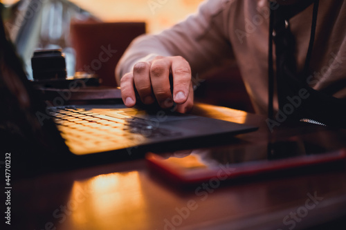Young man using laptop in cafe, make photo and video, hipster portrait, bears style, freelancer