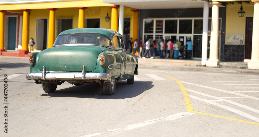 green classic car, retro, aluminum bumpers. Parked next to the building. free space for text