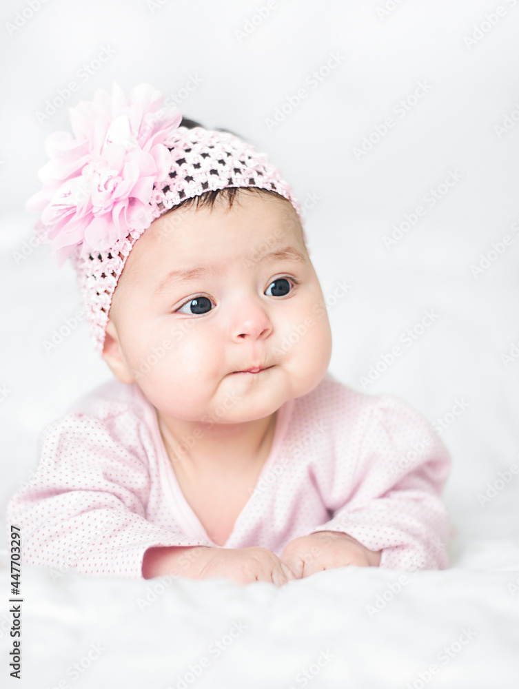 Baby girl lies and looks with interest at the world around Baby girl lies and looks with interest at the world around