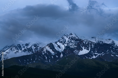 picturesque view of snow-covered mountains among clouds 
