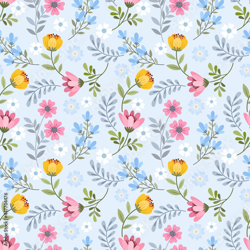 Cute blooming small flowers on blue background seamless pattern.