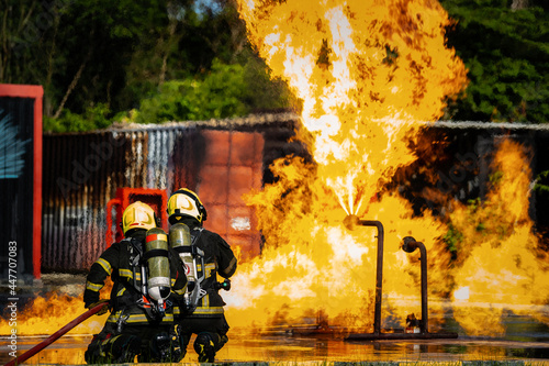 Firefighters are conducting fire drills by spraying water to extinguish the raging fire. photo