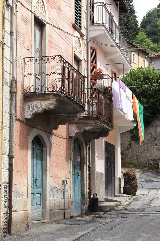 Central Italy Village View with Old House Facades, Green Doors, Iron Balconies and Hanging Laundry Central Italy Village View with Old House Facades, Green Doors, Iron Balconies and Hanging Laundry