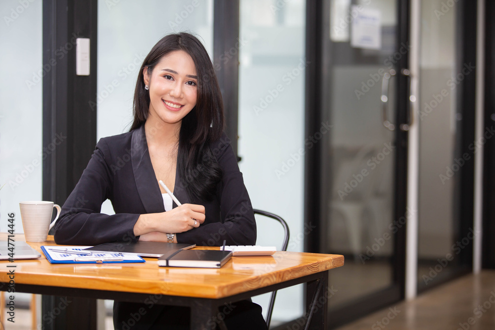 Portrait Beautiful Asian woman working happily and success in work and profit in business made by using PC Laptop Smart phone and business analysis chart Portrait Beautiful Asian woman working happily and success in work and profit in business made by using PC Laptop Smart phone and business analysis chart