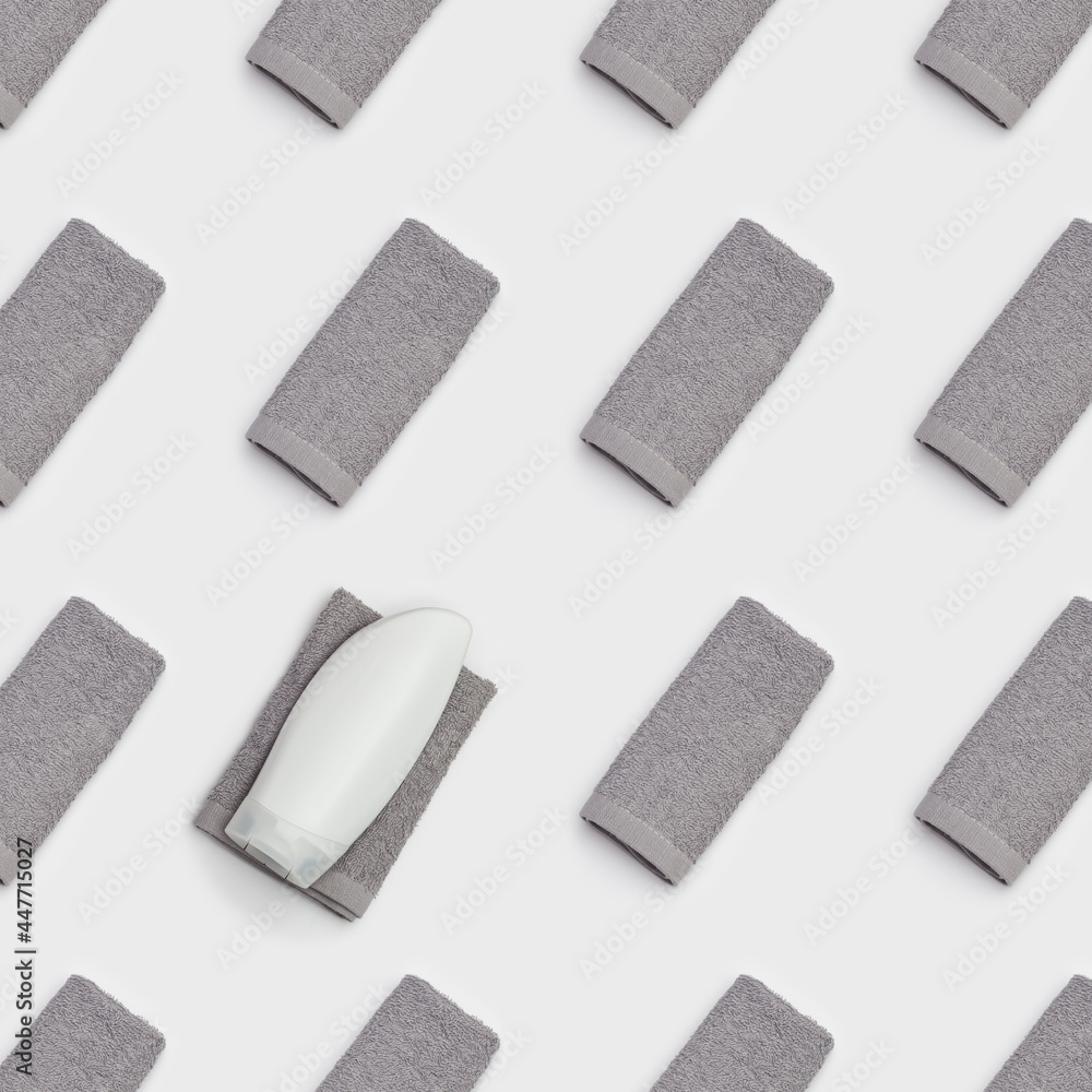Geometric pattern with bath towels grey colored. Folded Cotton soft towel, white plastic bottle for gel or shampoo. Geometric pattern with bath towels grey colored. Folded Cotton soft towel, white plastic bottle for gel or shampoo.