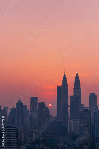 Travel lifestyle view of golden sunrise over city horizon and sky scrapers in Kuala Lumpur, Malaysia. photo