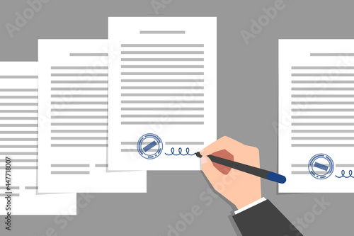 Stack of documents and hand of person signing them