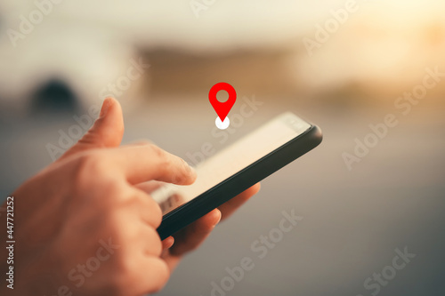 Foto Woman hand using smart phone with navigator location point at street background