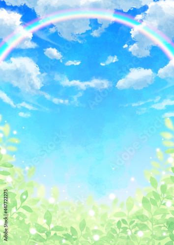 虹のかかる青空と雲と輝く葉っぱ