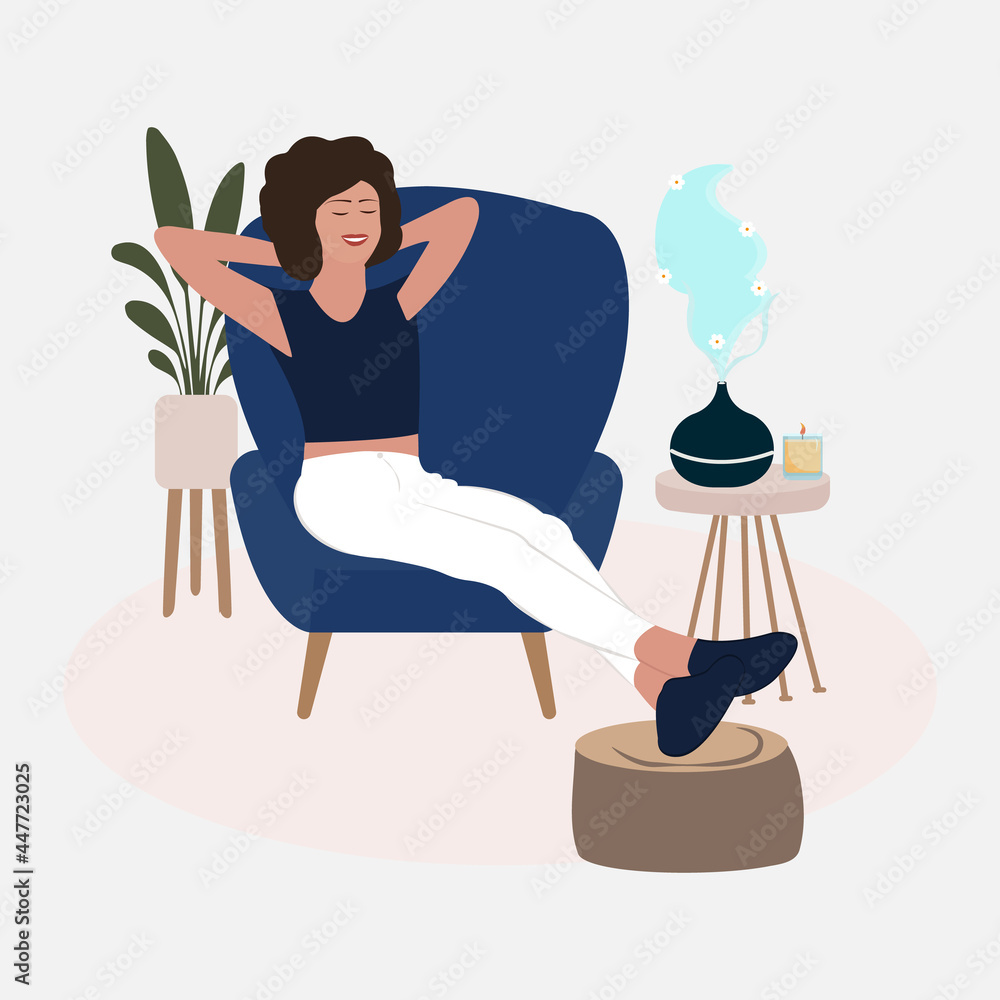 Aromatherapy Concept. Woman relaxing on the armchair while enjoying the aromatherapy in a minimalist living room. Home relaxation with aromatherapy from oil diffuser with flower smell.