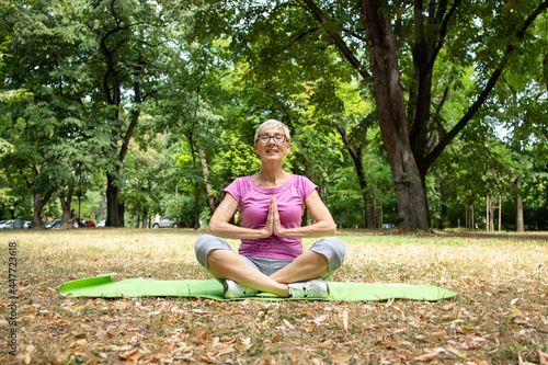 Senior caucasian woman enjoys doing yoga exercise.