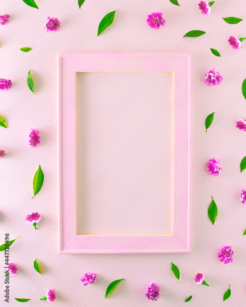 Wooden frame in nude pink with space for text with tiny pink flowers and green leaves. Aesthetics on pink backgrounds.