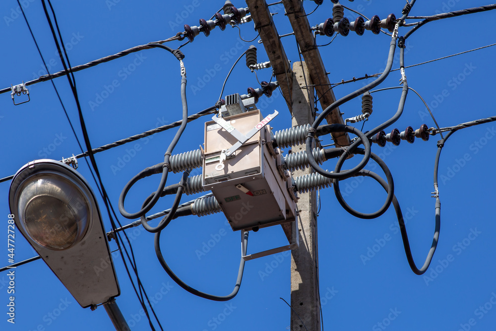 power utility pole with transformers and street light.