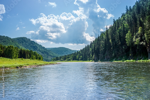 Landscape of Siberia. Kiya River  mountain banks and green forests in the Kemerovo region. Daytime landscape with blue skies and clouds.
