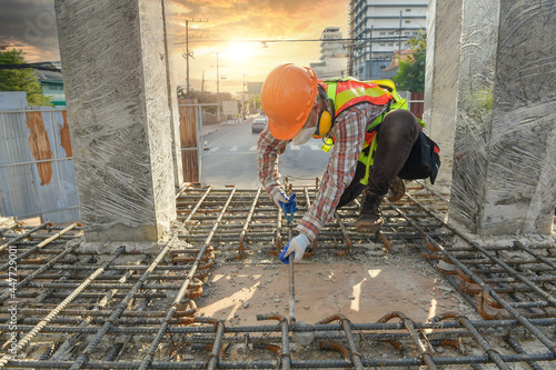 Construction Worker on a building site checking the foundations, Thailand