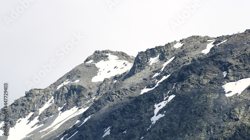 Fototapeta Naklejka Na Ścianę i Meble -  Snow capped rocky peak. View of a mountain range in summer or winter with snow at the top.