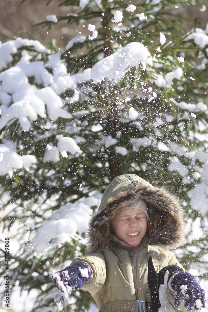 Child's joy in the snow falling from the branches of a spruce tree. Child's joy in the snow falling from the branches of a spruce tree.