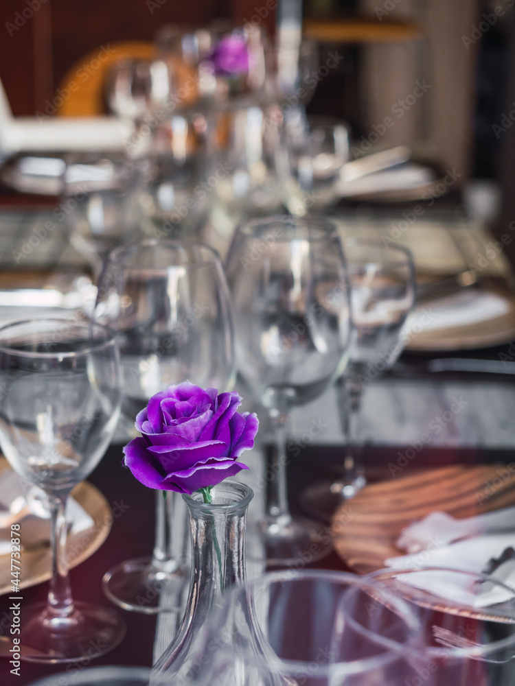 Restaurant table without people due to a pandemic crisis, with a purple flower