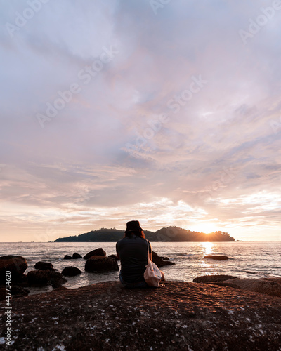 Man chilling by the beach at sunset