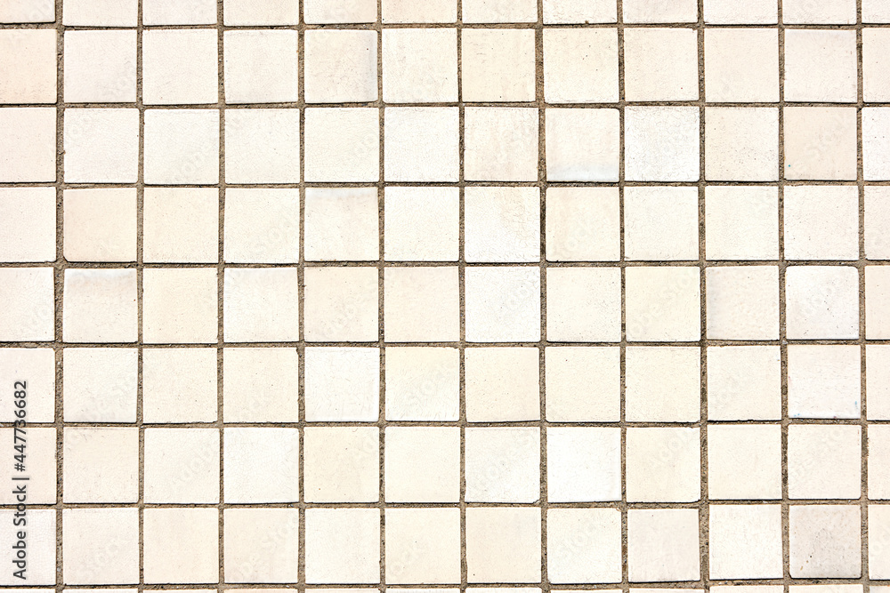 Background from a wall made of square beige mosaic tiles Background from a wall made of square beige mosaic tiles