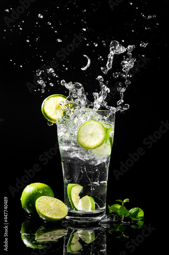 Cold lemonade with splash for summer refreshing drink isolated on a black background.