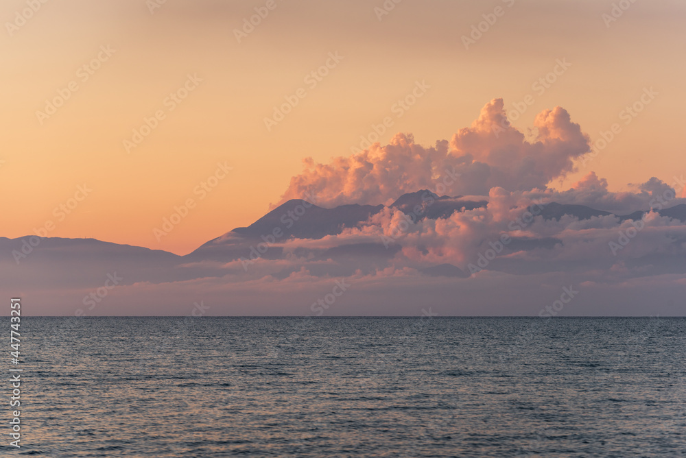 Albania coast surrounded by clouds during sunset seen from Corfu island in Greece
