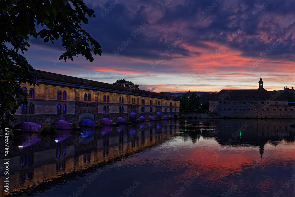 STRASBOURG, FRANCE, June 23, 2021 : Barrage Vauban at night. This bridge, weir and defensive work was erected in the 17th century on the Ill river, and named Great Lock.