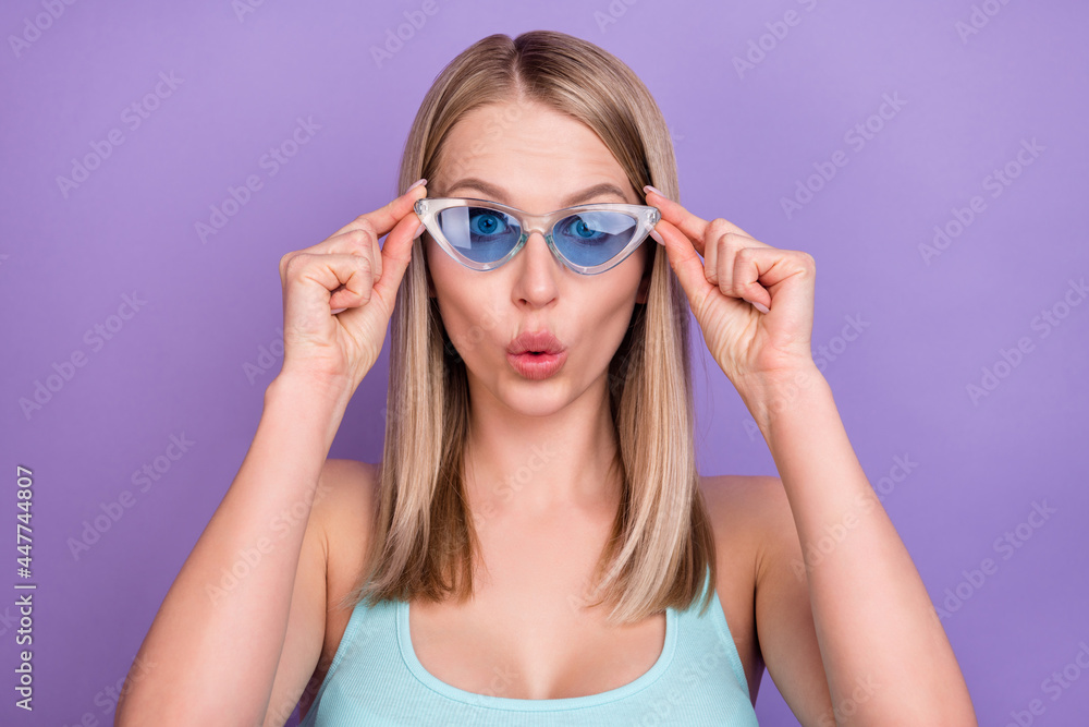 Photo of impressed blond young lady touch spectacles wear blue top eyewear isolated on violet color background Photo of impressed blond young lady touch spectacles wear blue top eyewear isolated on violet color background