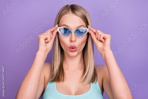 Photo of impressed blond young lady touch spectacles wear blue top eyewear isolated on violet color background