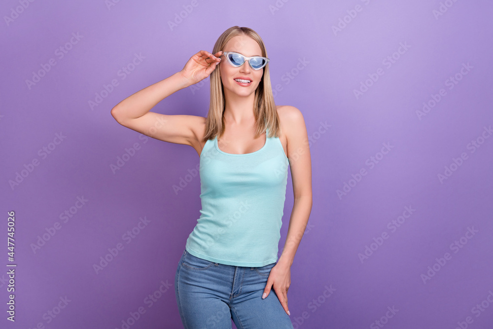 Photo of cool blond millennial lady look empty space wear blue top eyewear jeans isolated on violet color background Photo of cool blond millennial lady look empty space wear blue top eyewear jeans isolated on violet color background