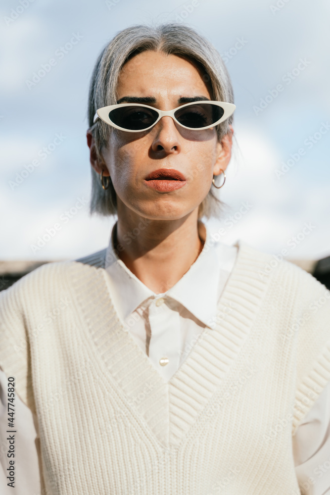 Stylish transgender woman sitting in armchair on terrace Stylish transgender woman sitting in armchair on terrace