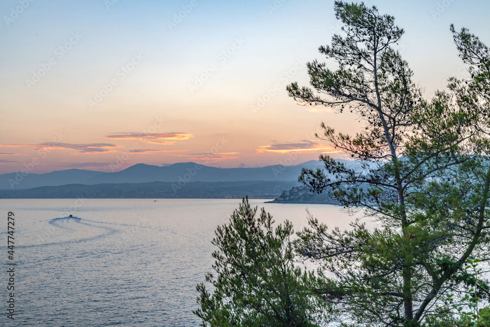 Coucher de soleil sur la Côte d'Azur depuis le Cap Ferrat avec vue mer et pins parasols Coucher de soleil sur la Côte d'Azur depuis le Cap Ferrat avec vue mer et pins parasols