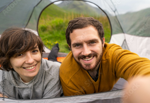 Obraz na płótnie Happy couple inside a tent taking a selfie and enjoying a romantic vacation camping in Scotland w salonie