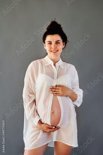 beautiful pregnant girl in a shirt with a bare stomach.