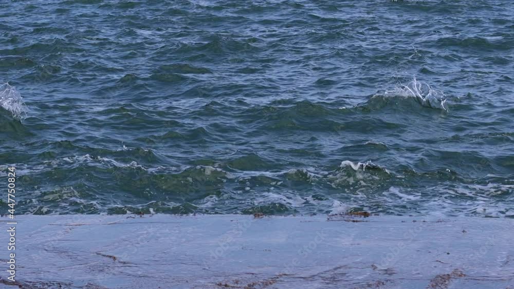 Beautiful blue sea with waves crashing on a stone pier. Strong streams of cold blue water. 4K Beautiful blue sea with waves crashing on a stone pier. Strong streams of cold blue water. 4K