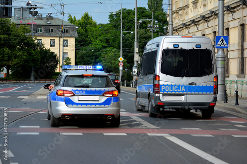 Polska policja drogowa podczas pracy na drodze w mieście. Pojazdy policyjne. 