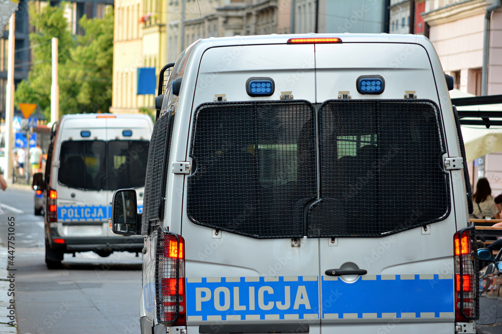Polska policja drogowa podczas pracy na drodze w mieście. Pojazdy policyjne.  - obrazy, fototapety, plakaty 
