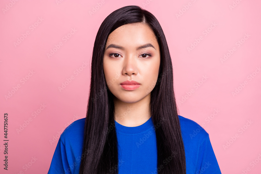 Photo of young serious asian woman wear blue t-shirt casual clothes isolated on pastel pink color background Photo of young serious asian woman wear blue t-shirt casual clothes isolated on pastel pink color background