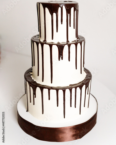 Cake three tiers with white cream decorated with chocolate