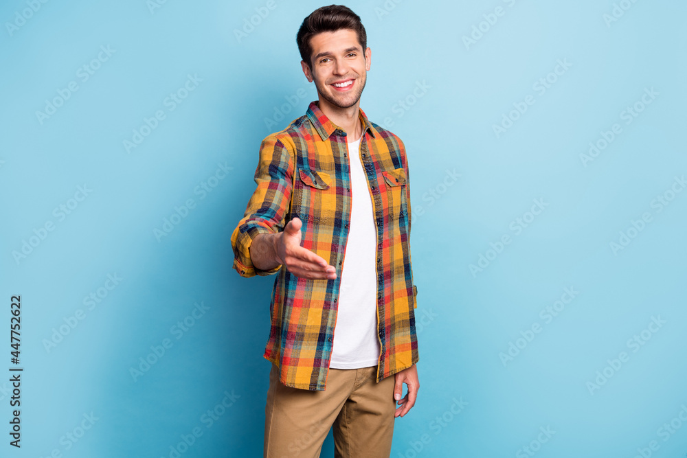 Portrait of attractive cheerful guy giving you hand welcoming new employee isolated over bright blue color background Portrait of attractive cheerful guy giving you hand welcoming new employee isolated over bright blue color background