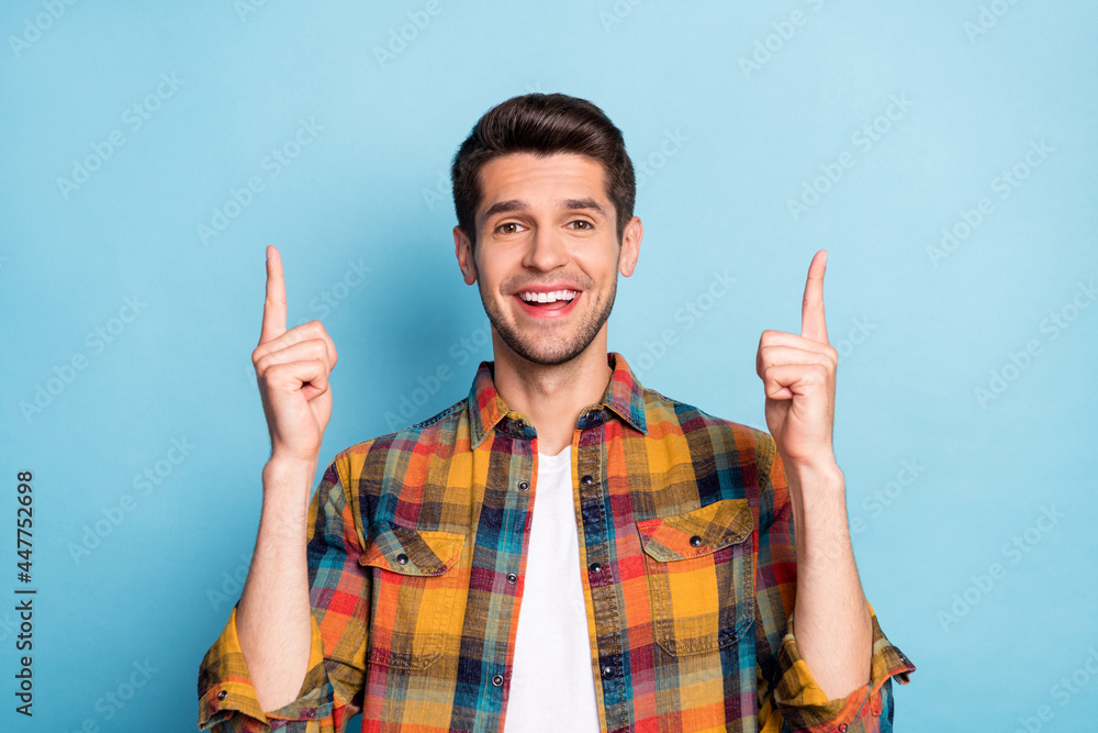 Portrait of attractive cheerful guy pointing forefingers up copy empty space isolated over bright blue color background Portrait of attractive cheerful guy pointing forefingers up copy empty space isolated over bright blue color background