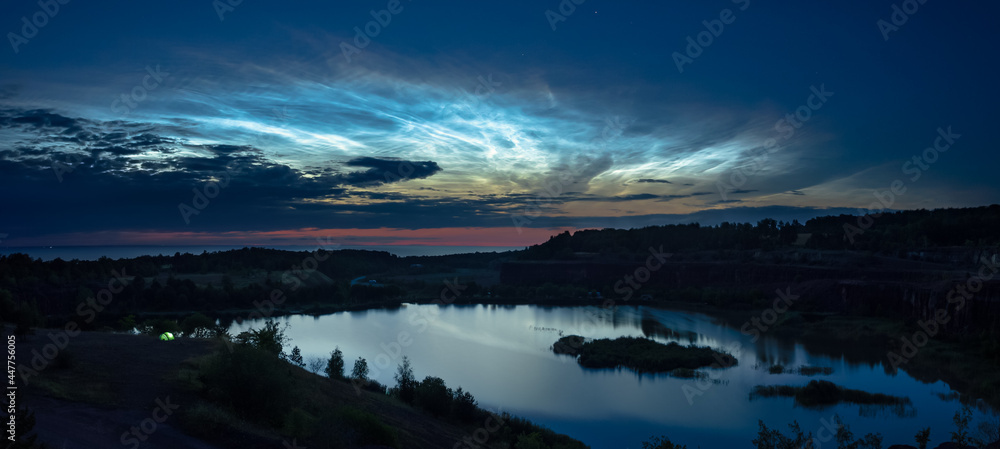 Panorama over an old quarry in the mountain Kinnekulle in Sweden with some beautiful noctilucent clouds. Panorama over an old quarry in the mountain Kinnekulle in Sweden with some beautiful noctilucent clouds.