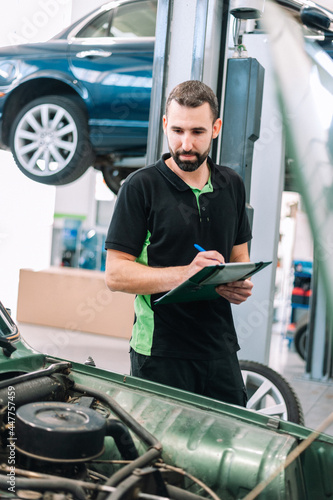 Mechanic taking notes while inspecting a car