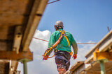 Hombre de espaldas caminando en techo de construcción 