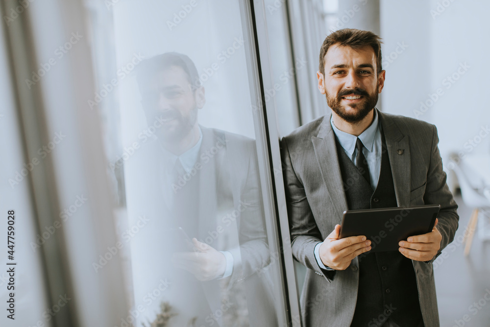 Fototapeta premium Young modern businessman using digital tablet in the office