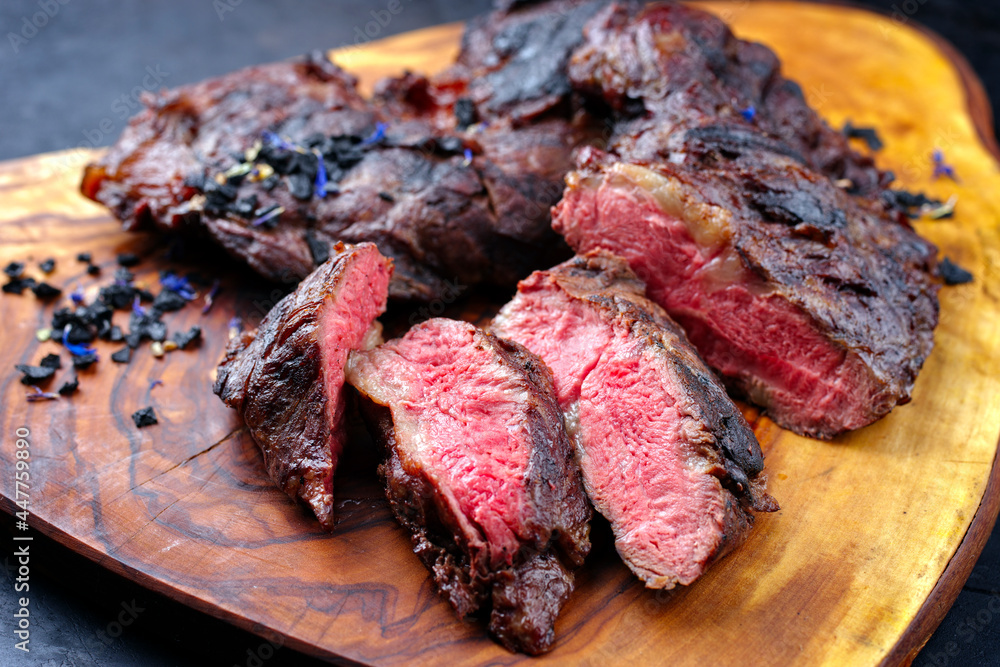 Traditional barbecue wagyu spider beef steak with black salt and spices served as close-up on a rustic wooden board Traditional barbecue wagyu spider beef steak with black salt and spices served as close-up on a rustic wooden board