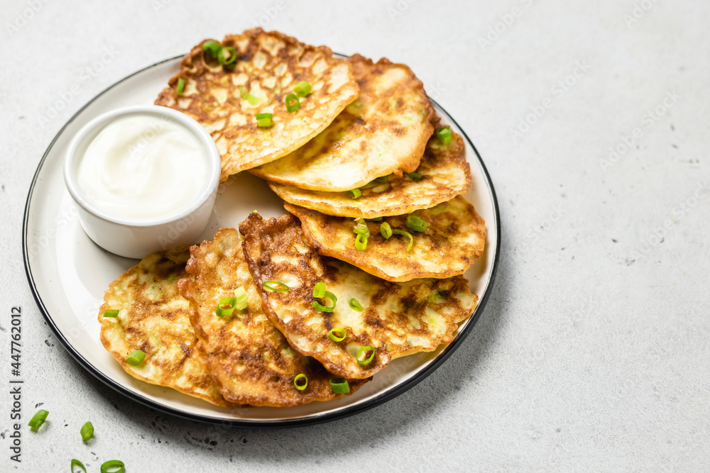 Cheesy zucchini pancakes with yogurt sauce. Space for text. Cheesy zucchini pancakes with yogurt sauce. Space for text.