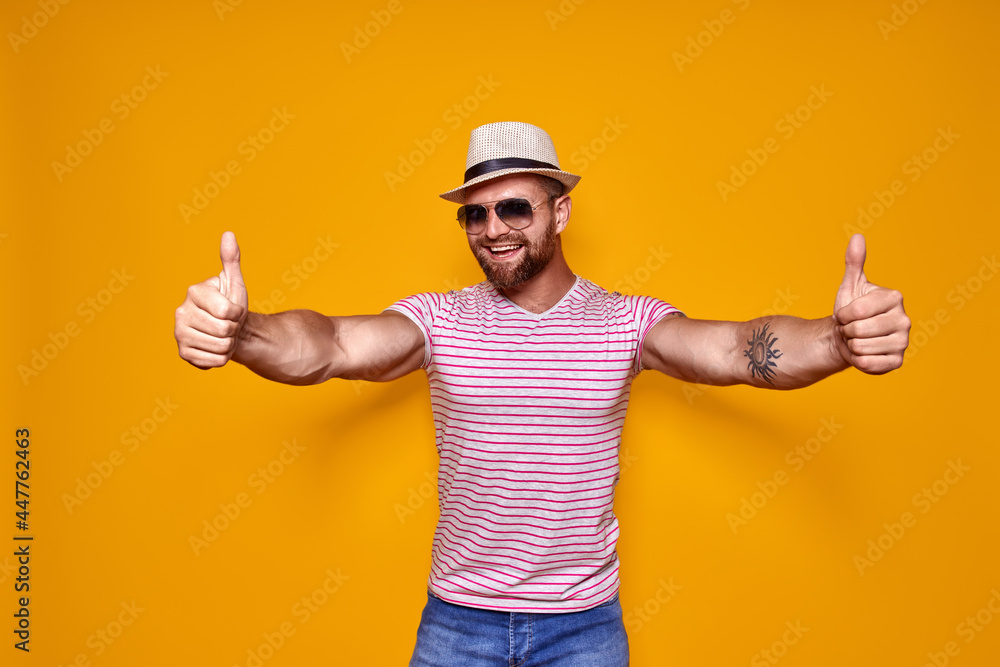 Bearded man in hat and sunglasses showing thumbs up Bearded man in hat and sunglasses showing thumbs up